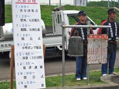 大会日程　半鐘と打ち手の第9分団永山班長と青柳班長