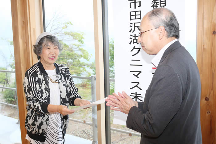 クニマス未未来館観覧者3万人目の澤山さん。